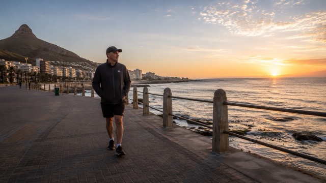 Person walking on a coastal path in the early morning